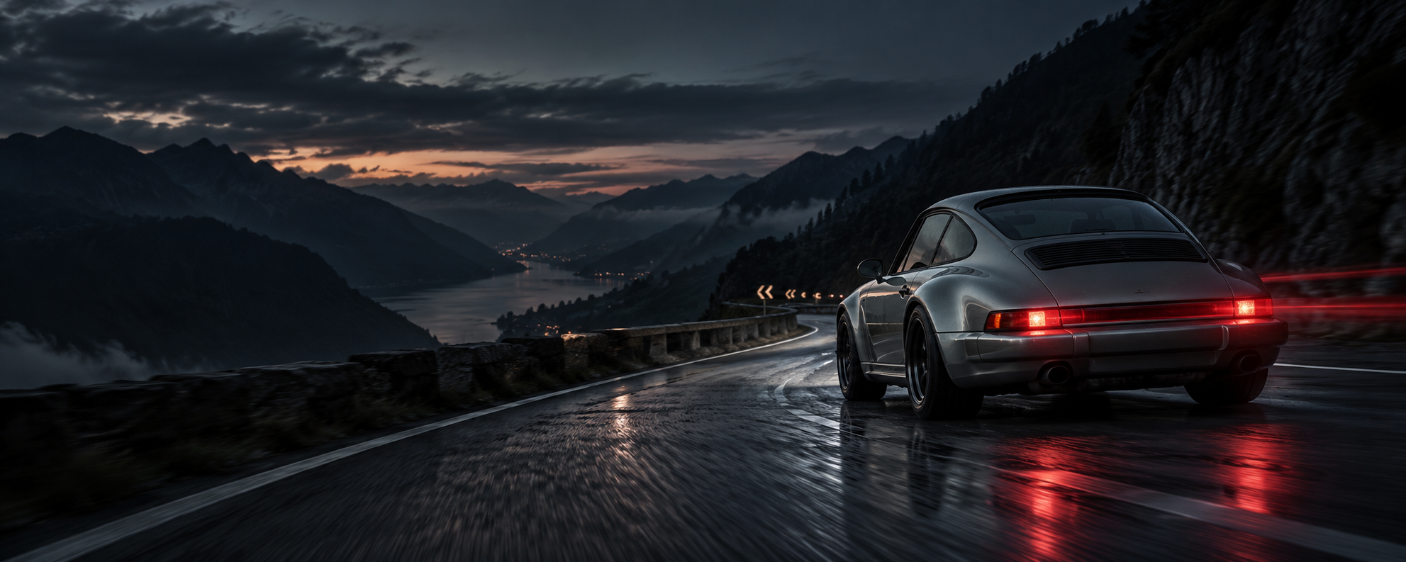 Classic silver Porsche-inspired sports car driving a mountain road at dusk